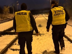 Patrol składający się z policjanta i funkcjonariusz Straży Ochrony Kolei sprawdzają rejon torowiska.