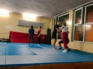 Na zdjęciu zajęcia z samoobrony dla kobiet w gliwickiej komendzie. Na macie prowadzone są ćwiczenia pod nadzorem instruktora.