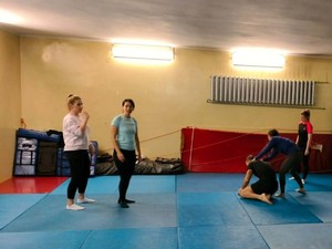 Na zdjęciu zajęcia z samoobrony dla kobiet w gliwickiej komendzie. Na macie prowadzone są ćwiczenia pod nadzorem instruktora.