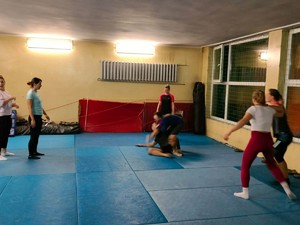 Na zdjęciu zajęcia z samoobrony dla kobiet w gliwickiej komendzie. Na macie prowadzone są ćwiczenia pod nadzorem instruktora.