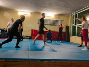 Na zdjęciu zajęcia z samoobrony dla kobiet w gliwickiej komendzie. Na macie prowadzone są ćwiczenia pod nadzorem instruktora.