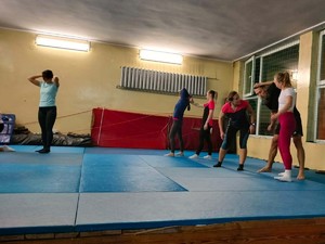 Na zdjęciu zajęcia z samoobrony dla kobiet w gliwickiej komendzie. Na macie prowadzone są ćwiczenia pod nadzorem instruktora.