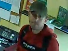 Sprawca przestępstwa w czapce bejsbolowej i czerwonej bluzie.