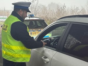 Policjant ruchu drogowego przeprowadza badanie stanu trzeźwości kierującego samochodem
