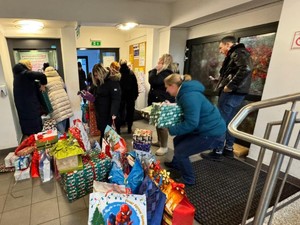 Na holu Ośrodka pracownicy krzątają się wnosząc paczki.