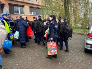 Wszyscy uczestnicy akcji wnoszą prezenty do budynku po schodach