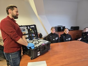 Nieumundurowany policjant-technik kryminalistyki, prowadzi zajęcia dla uczniów klas policyjnych