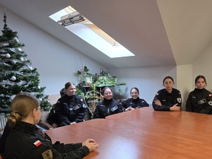 Przy stole siedzą uczniowie klasy policyjnej