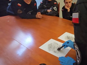 Uczennica klasy policyjnej zbiera odciski palców.