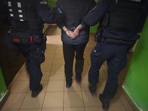 Zatrzymany w kajdankach prowadzony jest przez policjantów