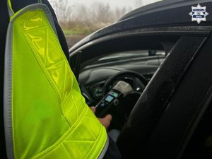 Policjant bada stan trzeźwości kierującego pojazdem