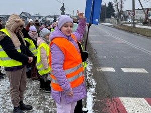 Grupa dzieci stoi przed oznakowanym przejściem dla pieszych