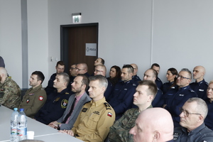 Na dużej sali siedzą przedstawiciele Policji i zaproszonych służb