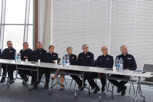 funkcjonariusz siedzą na krzesłach przy stole