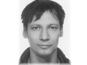 Na zdjęciu młody mężczyzna w ciemnych włosach. Zdjęcie twarzy.