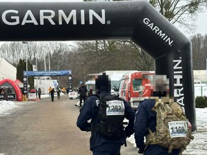 Na zdjęciu dwóch umundurowanych policjantów wbiega na metę półmaratonu