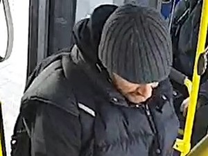 Na zdjęciu mężczyzna w średnim wieku w autobusie. Na głowie ma szarą czapkę.