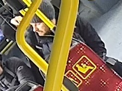 Na zdjęciu mężczyzna w średnim wieku w autobusie. Na głowie ma szarą czapkę.