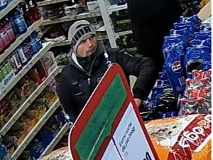 Mężczyzna w szarej czapce z napisem PUMA i kurtce.