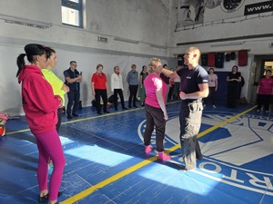 Policjant demonstruje kobiecie schemat obrony