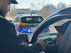 Na zdjęciu policjant bada stan trzeźwości kierującego pojazdem
