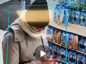 Na zdjęciu wizerunek kobiety w czapce czarnej, szaliku i kurtce - zarejestrowany przez monitoring sklepowy