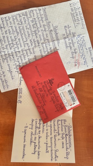 Na zdjęciu jest widoczna koperta wraz  z listem i kartka świąteczna.