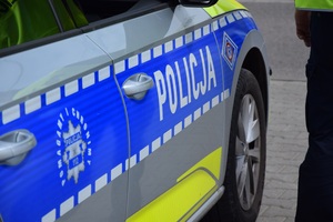 Na zdjęciu widać bok radiowozu oznakowanego z napisem policja.
