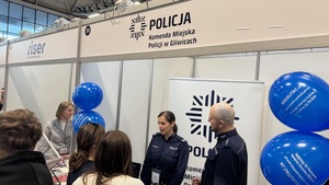 na zdjęciu widzimy stanowisko policji podczas targów pracy, policjant i policjantka rozmawiają z kilkoma osobami.