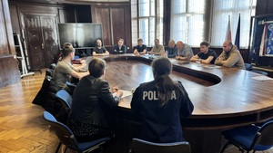 Na zdjęciu widzimy rozmawiących funkcjonariuszy - policjantki  z nowo przyjętymi policjantami. Zdjęcie zrobione za plecami.