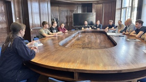 Na zdjęciu widzimy rozmawiących funkcjonariuszy - policjantki  z nowo przyjętymi policjantami. Zdjęcie zrobione z boku.