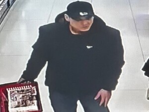 Na zdjęciu mężczyzna w czapce z daszkiem i koszykiem w ręku robi zakupy w sklepie