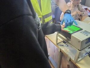 Technik kryminalistyki pobiera od kobiety odciski palców