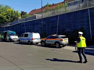 Policjant idzie w kierunku stojących radiowozów różnych służb