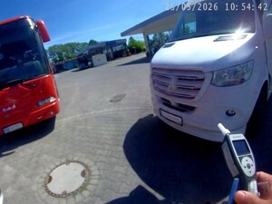 Urzadzenie do badania stanu trzeźwości na tle stojących autokarów