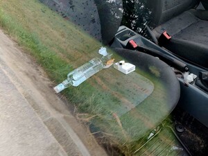 Na przednim siedzeniu leży butelka z alkoholem