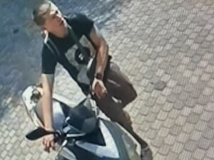 Na zdjęciu młody chłopak w ciemnej koszulce i długich spodniach, prowadzący motorower.