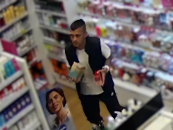 Mężczyzna o ciemnej karnacji, ciemne włosy podczas robienia zakupów w drogerii.