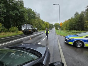 Na zdjęciu radiowóz Policji, WP oraz pojazd osobowy. Na jezdni stoi policjant